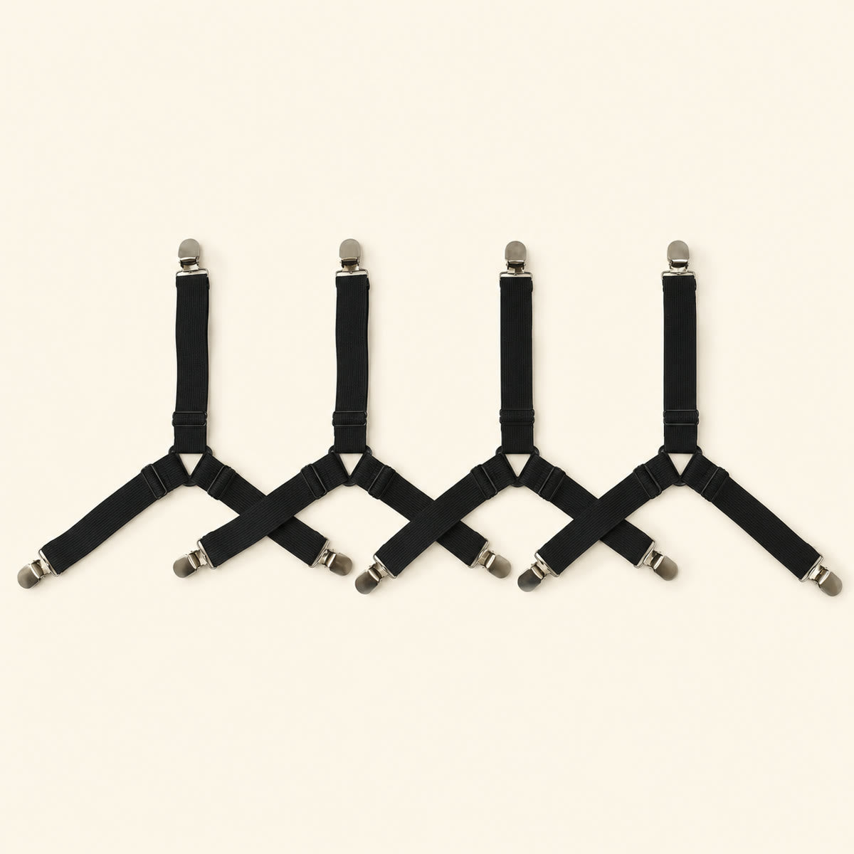 Four adjustable black fitted-sheet corner straps with metal clips