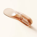 Translucent orange Tuckora mattress lifter on a warm ivory background