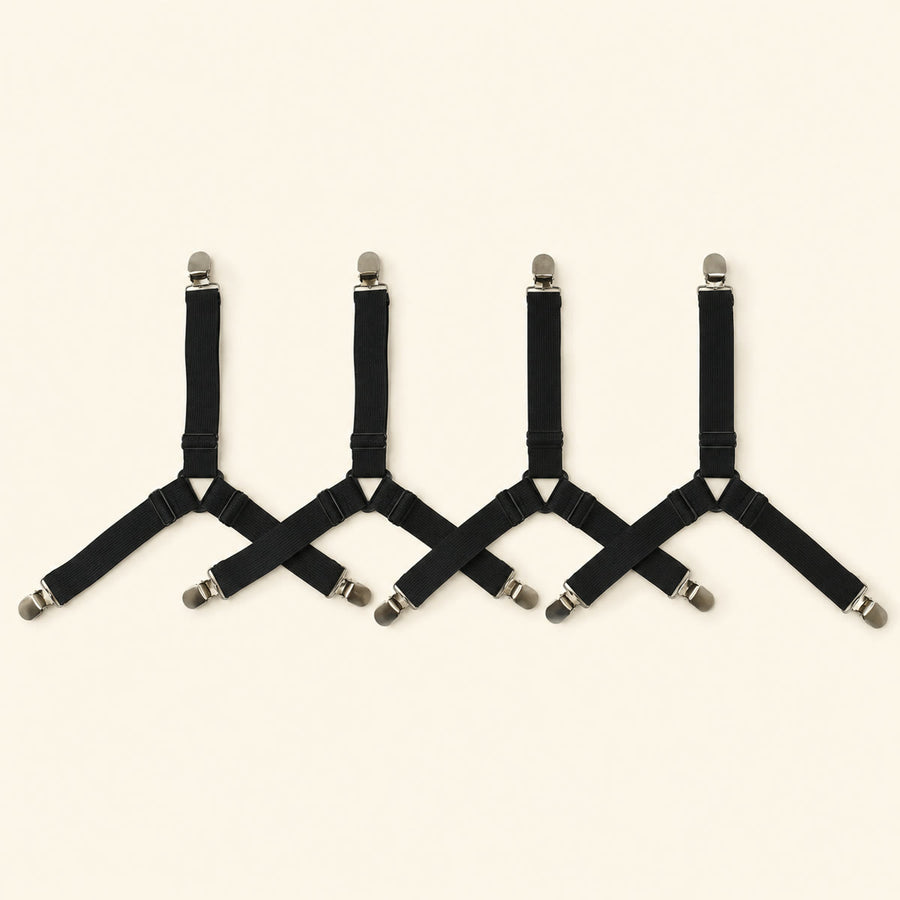 Four adjustable black fitted-sheet corner straps with metal clips